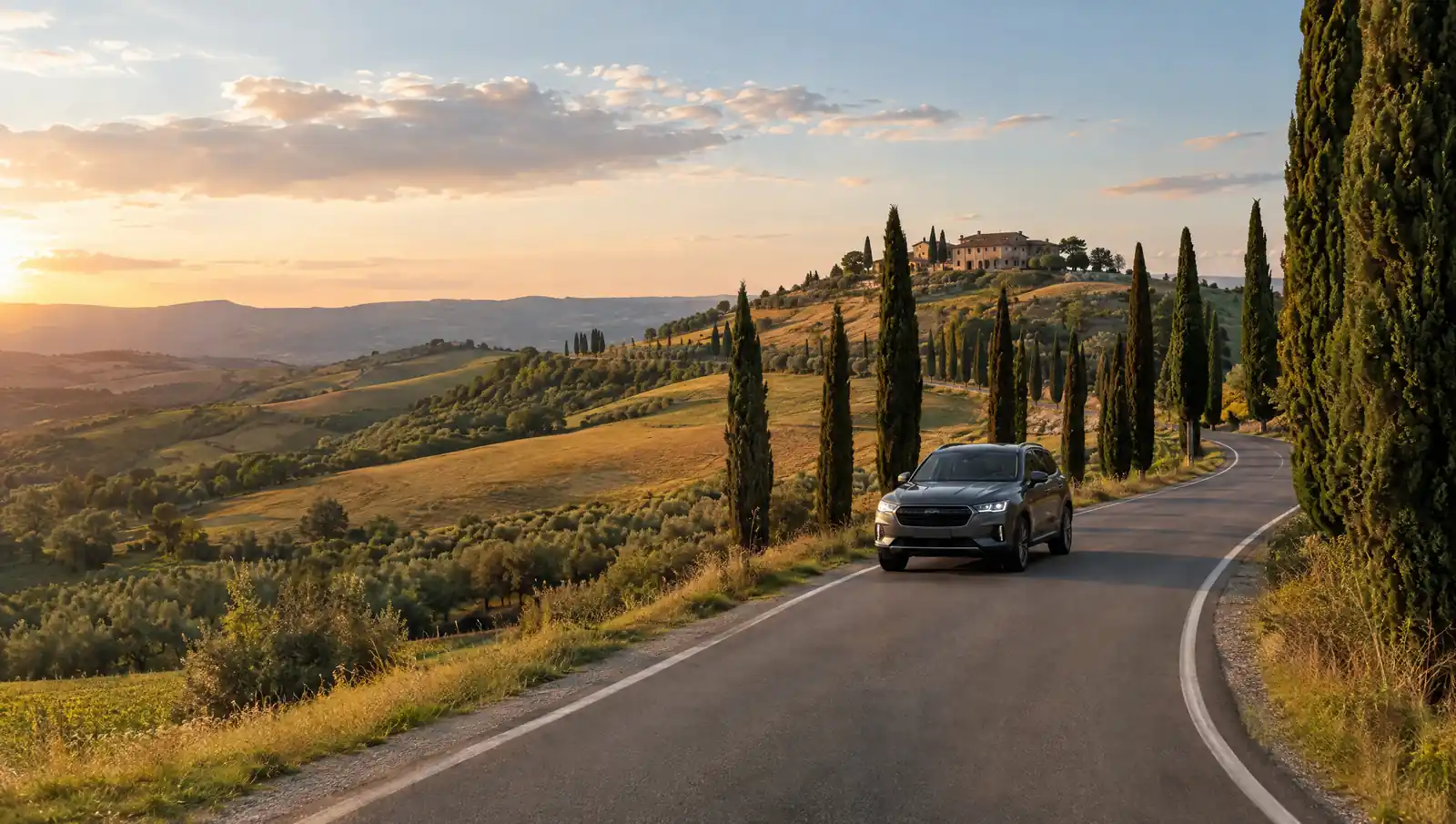 Temno siv SUV na cesti s cipresami med toskanskimi griči v Italiji